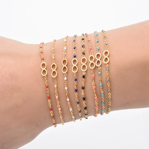 Bohemian gold infinity bracelets with colorful beads shown layered on a woman wrist