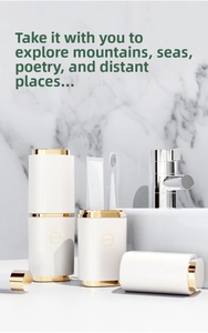Close-up of portable toothbrush holder with gold trim on marble bathroom vanity