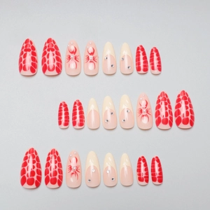 Long stiletto press-on nails with red scale textures, floral patterns and pearls