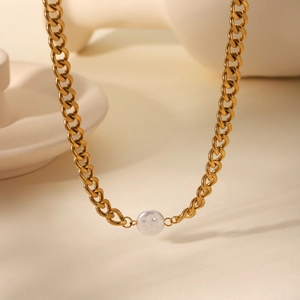Detailed macro view of vintage gold Cuban chain necklace with an elegant white pearl pendant