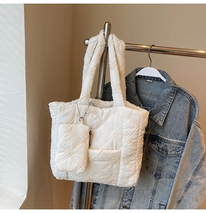Detail of white quilted tote bag with floral embroidery and matching coin purse