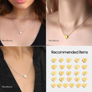 Close-up of heart-shaped alphabet pendants in gold and silver stainless steel