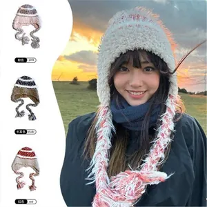 Detail view of plush winter bucket hat with long tassels and varied color swatches