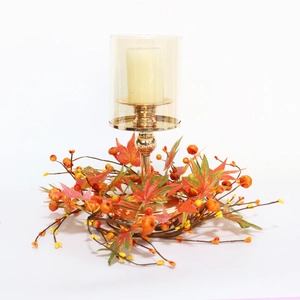 Detail of autumn candle holder with maple leaf wreath and amber glass for decor