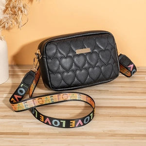 Close-up of heart quilted pattern on black bag with LOVE lettered fabric strap