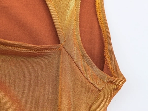 Macro du tissu métallique marron doré avec détails de couture précis sur la bretelle