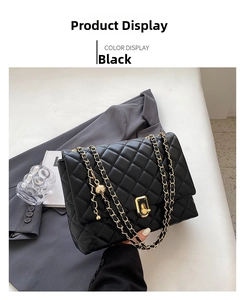 Detail of black quilted chain bag with gold metal clasp and adjustable ball charm