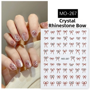 Detailed view of 5D embossed nail art stickers with red bows and crystal accents