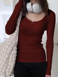 Detail of burgundy long sleeve top featuring lace patchwork neckline and button accents