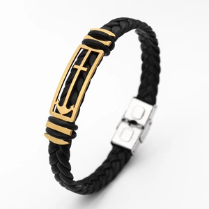 Detail view of black woven leather bracelet with gold anchor and cross charm and silver clasp