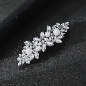 Détail macro d'une pince à cheveux avec strass marquise étincelants et perles blanches