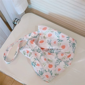 Detail of floral printed canvas tote bag with wide shoulder strap and pink peony pattern