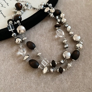Detail of vintage double-layer necklace with wood beads, silver metal, and crystal accents