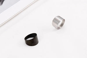 Macro shot of wide minimalist titanium steel rings in silver and black finishes