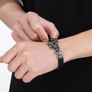 Macro detail of braided leather bracelet with vintage silver motorcycle rider metal clasp