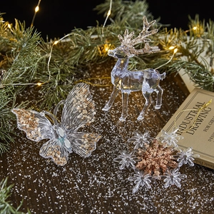 Three transparent acrylic Christmas ornaments with reindeer and snowflake in gold glitter