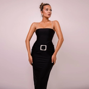 Detail of elegant black slim-fit evening dress with sparkling rhinestone straps and waist buckle