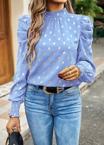 Detail view of blue blouse with gold foil dots, smocked cuffs and elegant puff shoulders