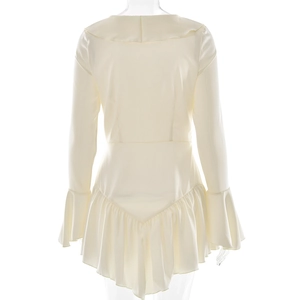Détail d'une robe blanche à col en V avec ourlet à volants et poignets évasés élégants