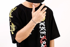 Detail view of a silver hip hop steel chain bracelet with a lobster clasp on a wrist