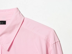 Close-up of pink poplin shirt collar and shoulder seam with size S brand label detail