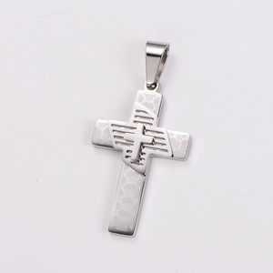 Macro shot of silver stainless steel cross pendant featuring geometric arrow textures