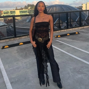 Look urbain du mannequin en haut en dentelle noire et jean bleu droit sur un toit-terrasse