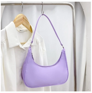 Detail view of purple nylon crescent shoulder bag hanging on a hanger with silver hardware