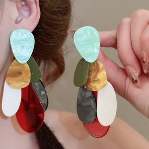 Detailed macro view of colorful geometric acrylic drop earrings with marble texture