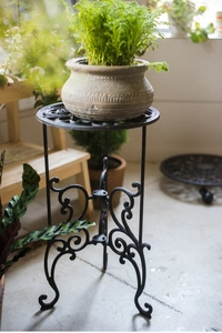 Vue détaillée du support de plante en fonte noire avec des volutes classiques de jardin