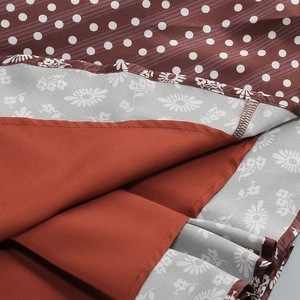 Close-up of brown polka dot hem and floral pattern with red lining detail