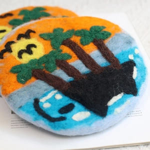Handmade tropical sunset wool felt coaster with palm tree and bird in soft needle felt