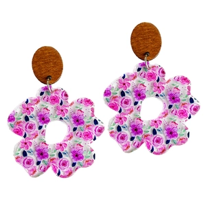 Acrylic floral earrings with pink and purple petals and a circular brown wood top