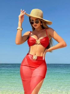 Dettaglio del bikini rosso tre pezzi con gonna in rete e fibbie a forma di stella marina