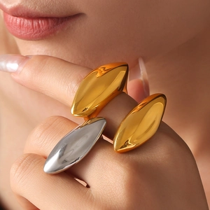 Artistic streamlined teardrop rings in gold and silver finish worn by a model