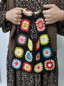 Detailed close-up showing the handmade crochet texture and colorful floral granny squares