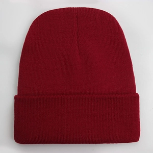 Close-up of wine red knitted beanie showing fine textured stitching and warm yarn material