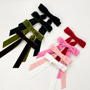 Detail of colorful velvet bow hair clips with long ribbons in seven different shades