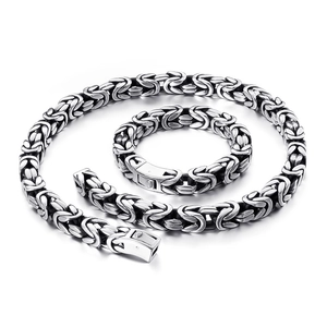 Byzantine chain necklace and bracelet set in silver-tone stainless steel on white background