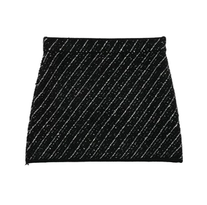 Close-up of a black textured knit mini skirt with white blended yarn detailing