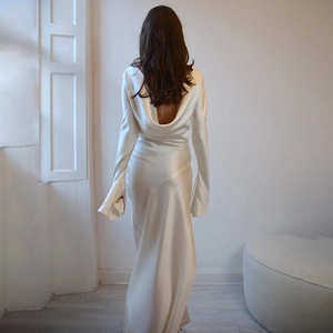 Elegant white backless satin evening gown with long sleeves and flowing drape detail