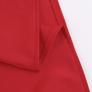 Detailed view of the split hem and stitching on a red satin bodycon dress