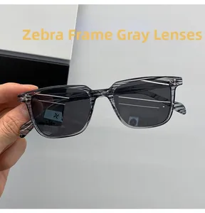 Vue détaillée des lunettes de soleil tendance à monture zébrée et verres gris