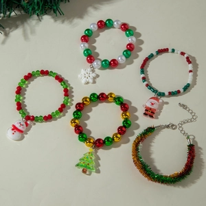 Detailed flat lay of Christmas beaded bracelets with Santa and tree charms