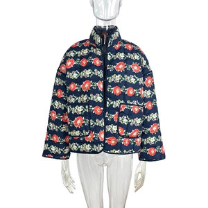 Detail of floral quilted jacket featuring stand collar and navy blue floral patterns