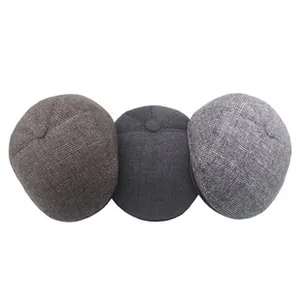 Detailed view of three wool blend newsboy caps in plaid and solid grey and brown textures