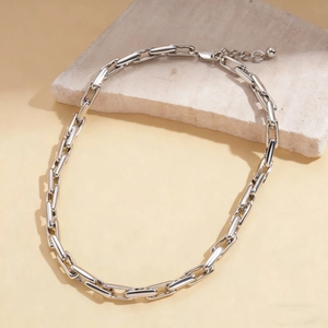 Close-up of silver geometric link chain necklace with lobster clasp and adjustable tail