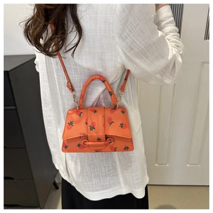 Achteraanzicht van model met een mini oranje crossbodytas met aardbeienprint en leren riem