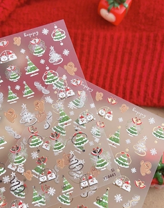 Close-up of Christmas nail stickers with gingerbread man and snowflake patterns