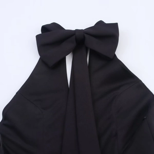 Gros plan du décolleté licou avec détail de nœud papillon sur une robe tissée noire